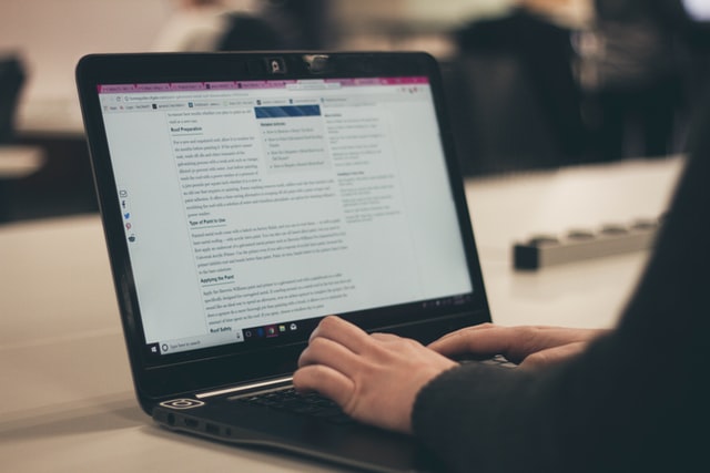 woman writing a blog post on a laptop