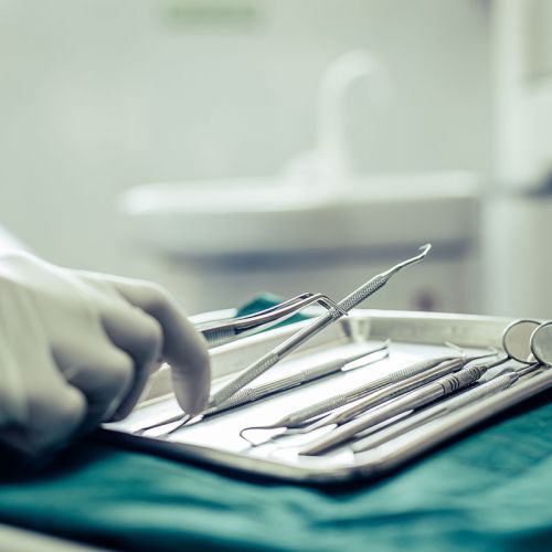 dentist picking up dental tools
