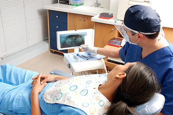 doctor showing a patient a xray, she is laying on a treatment bed