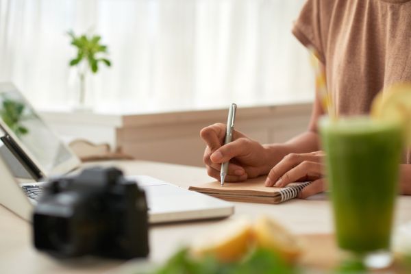 blogger writing down notes